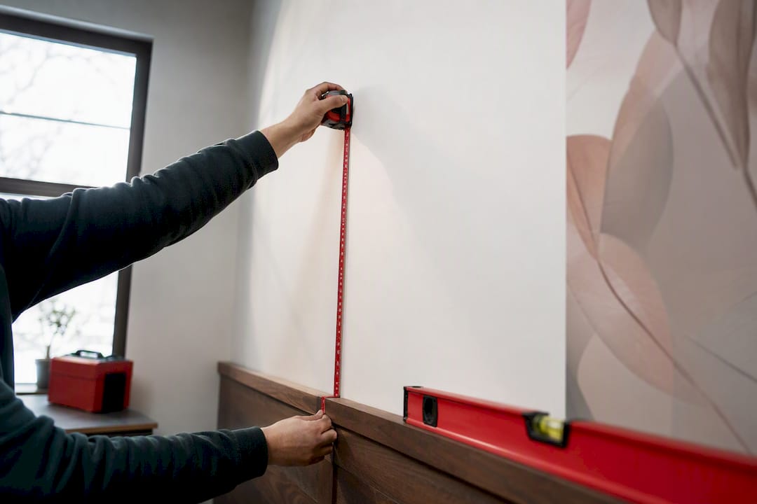 Hands measuring a wall for a mural