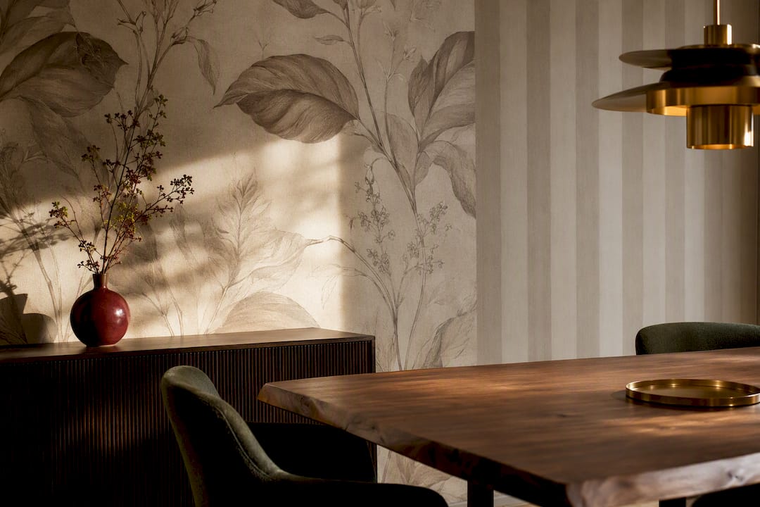 Layered wallpaper patterns in a warm dining room
