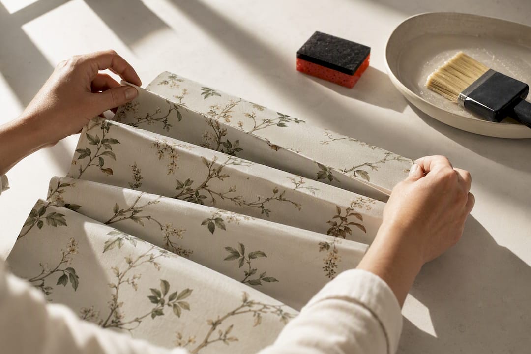 Hands booking a pasted wallpaper strip