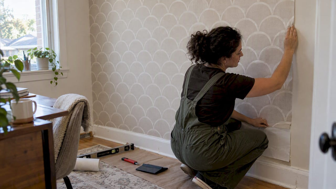 Homeowner installing scallop wallpaper accent wall